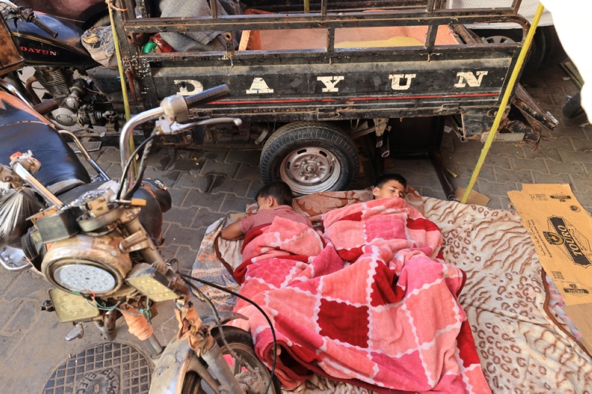 KHAN YUNIS: Internally displaced Palestinian children sleep on the ground as they and others are camped in the grounds of Al-Nasser hospital in the southern Gaza Strip on Nov 9, 2023. -- AFP photos 