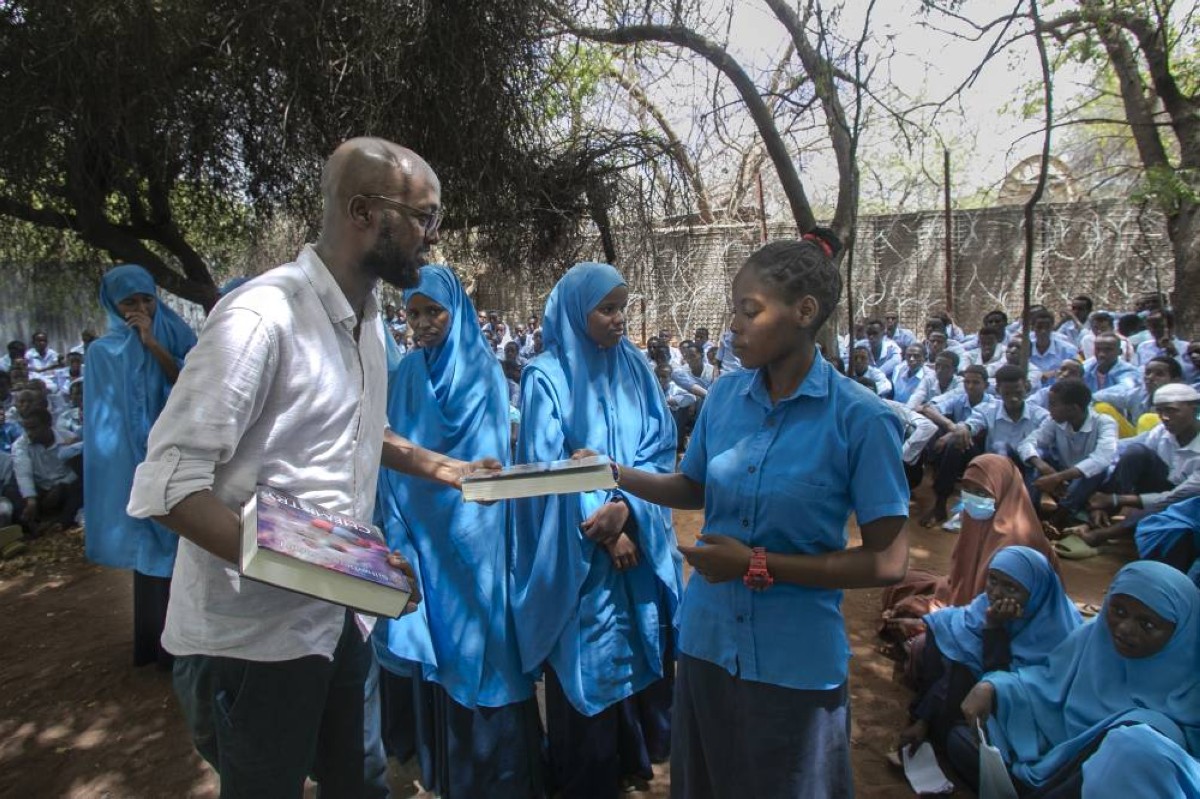 This handout picture shows Abdullahi Mire (left) the winner of the UN refugee agency&#039;s prestigious Nansen Award distributing books to refugee students in Kenya’s Dadaab refugee camp.--AFP photos