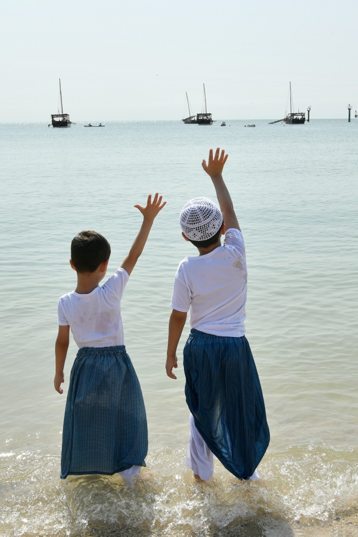 KUWAIT: Children wave at the divers aboard wooden boats as they begin the annual pearl diving festival. 