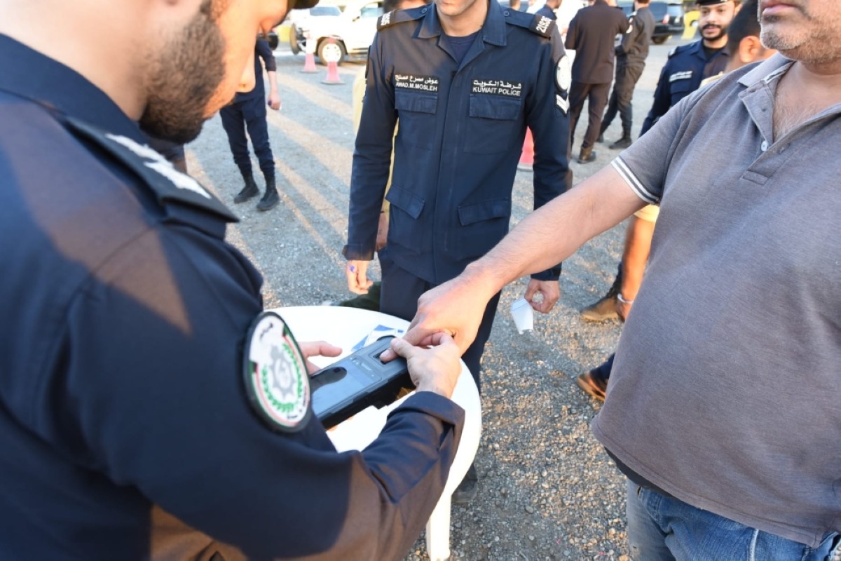 
Interior ministry personnel take an expat’s fingerprint to check their residency status during a security campaign on July 1, 2024. 