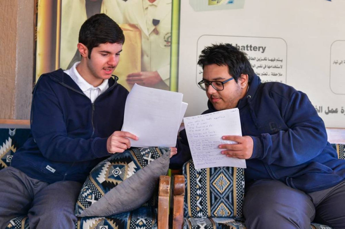 
Two students share notes while reviewing their study materials before taking their exam. 