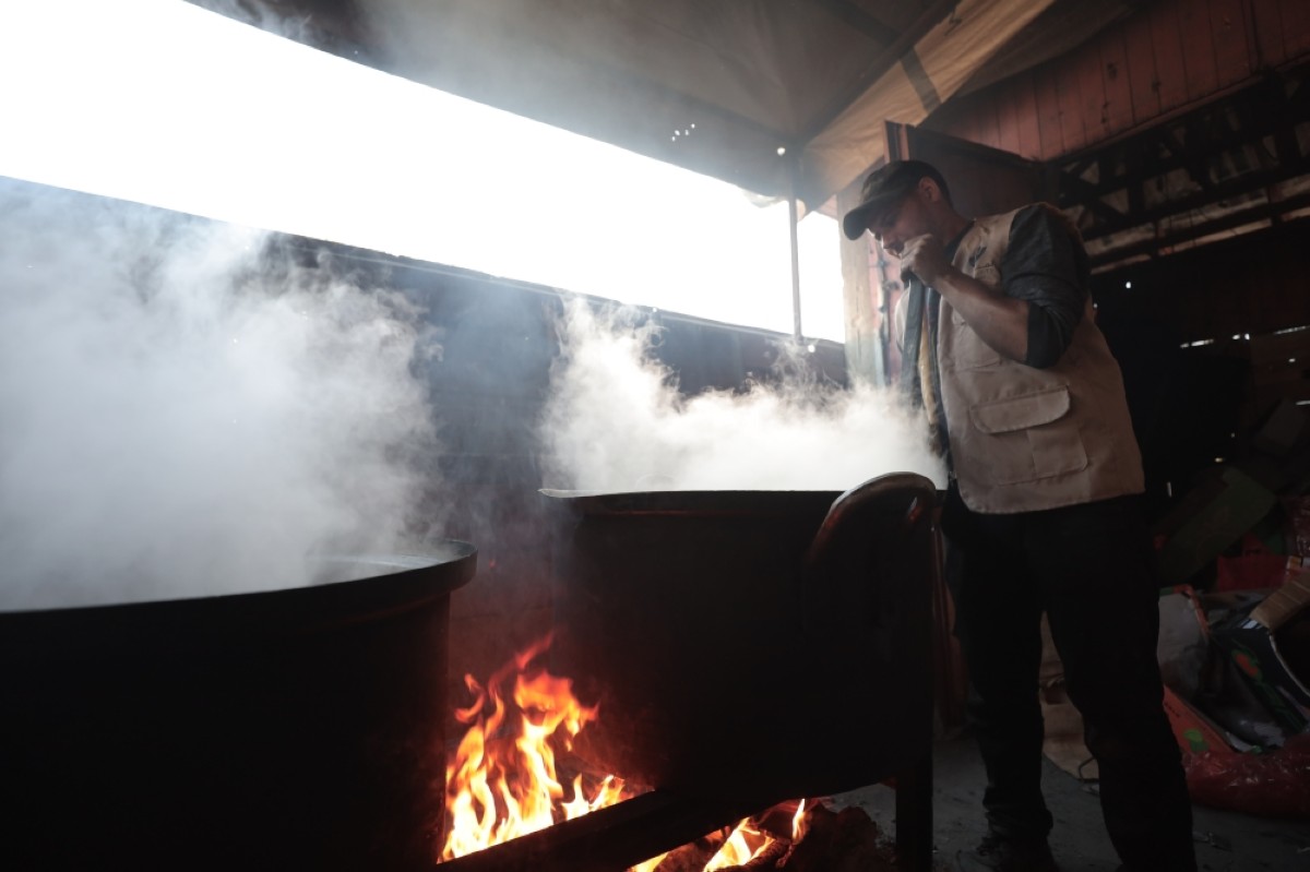 A charity worker cooks meals to feed forcibly displaced people in northern Gaza. 