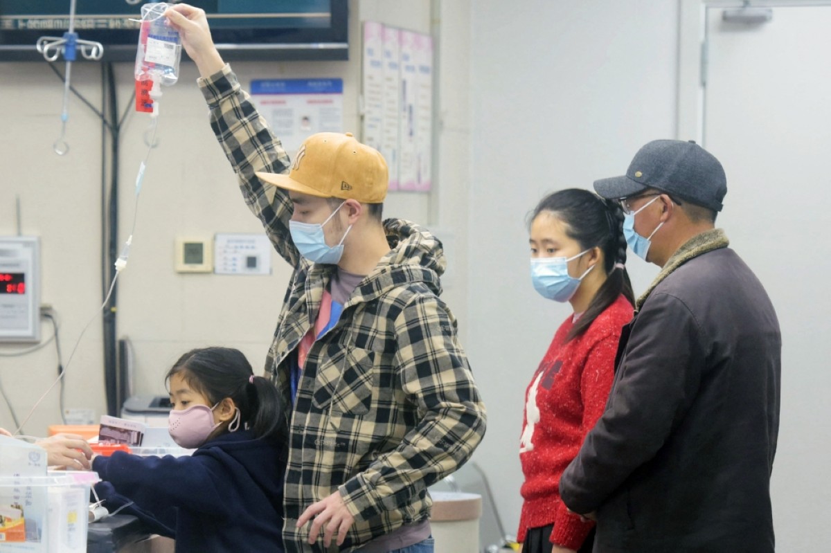 HANGZHOU: A family member holds an IV drip for a child receiving care at the pediatric department of a hospital in Hangzhou, eastern China&#039;s Zhejiang province, on January 6, 2025. —  AFP photos 