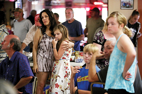 CLEARLAKE OAKES, CA - AUGUST 04: Laureen Lee (L) embraces her daughter Bella Lee (R) as they listen during a fire update at the Moose Lodge where several dozen Rocky Fire evacuees are staying on August 4, 2015 in Clearlake Oakes, California. Nearly 3,000 firefighters are battling the Rocky Fire that has burned 65,000 acres has forced the evacuation of 12,000 residents in Lake County. The fire is currently 12 percent contained and has destroyed at least 14 homes. 6,300 homes are threatened by the fast moving blaze.   Justin Sullivan/Getty Images/AFPn== FOR NEWSPAPERS, INTERNET, TELCOS &amp; TELEVISION USE ONLY ==
