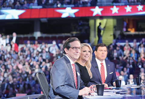 An August 6, 2015 photo shows prime time Republican presidential primary debate moderator Megyn Kelly (C) flanked by fellow moderators Chris Wallace (L) and Bret Baier (R) moments before the candidates arrived on stage at the Quicken Loans Arena in Cleveland, Ohio.   Donald Trump has been disinvited from a Republican party event on August 8, 2015 over a suggestion that a debate moderator was tough on him because she was menstruating. The off-handed comment unleashed a new storm of criticism of Trump and put him in spin control mode as he sought to nuance his remark. AFP PHOTO/MANDEL NGAN
