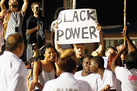Demonstrators protest during a march on August 8, 2015 at the Ferguson Police Department in Ferguson, Missouri. Several hundred people marched Saturday in Ferguson to mark the first anniversary of the police shooting of unarmed black teen Michael Brown, which shone a spotlight on race relations in America. The crowd worked its way along one of the avenues hit by fierce rioting last November when a court decided not to indict the white officer who shot 18-year-old Brown.  AFP PHOTO/MICHAEL B. THOMAS