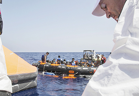 Survivors of the capsizing and sinking of a fishing boat crowded with migrants are brought aboard Irish and Italian Navy life-boats to the Dignity I MSF search and rescue vessel which responded to the emergency in the Mediterranean sea off Libya, Wednesday, Aug. 5, 2015. The Italian coast guard and Irish navy said at least 367 people were saved, although 25 bodies also were found in the latest human smuggling tragedy. (Marta Soszynska/MSF via AP)