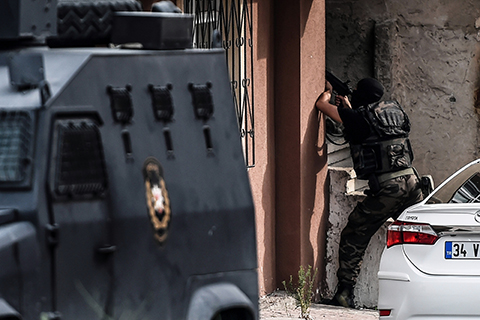 A special force police officer is seen during clashes with attackers on August 10, 2015 at the Sultanbeyli district in Istanbul. Turkey's largest city Istanbul was Monday shaken by twin attacks on the US consulate and a police station as tensions spiral amid the government's air campaign against Kurdish militants. AFP PHOTO / OZAN KOSE