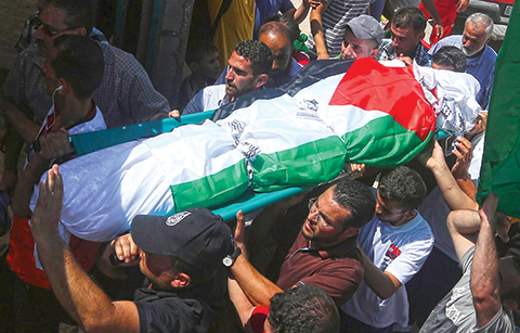 Palestinian men carry the body of Saad Dawabsha, the father of a Palestinian toddler killed last week when their home was firebombed by Jewish extremists, during his funeral in the West Bank village of Duma on August 8, 2015. Dawabsha succumbed in hospital in the southern Israeli city of Beersheba where he was being treated for third degree burns while his wife Riham and four-year-old son Ahmed are still fighting for their lives. AFP PHOTO / JAAFAR ASHTIYEH