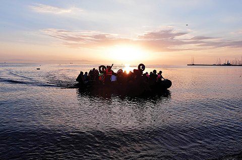 Syrian migrants  arrive on an overcrowded dinghy to the coast of the southeastern Greek island of Kos from Turkey, on August 15, 2015. A ferry boat has been sent by the Greek government to the resort of Kos to speed up the registration process of hundreds of Syrian refugees, docked on August 14 afternoon at the harbour. The Eleftherios Venizelos will stay moored in Kos for some two weeks, during which time authorities will register newcomers to the island, which is already overflowing with refugees and migrants. AFP PHOTO /LOUISA GOULIAMAKI