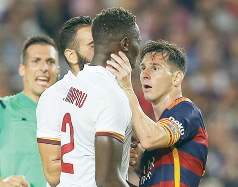 Barcelona's Lionel Messi, right, and Roma’s Mapou Yanga-Mbiwa get involved in a scuffle during the Joan Gamper trophy soccer match between FC Barcelona and AS Roma at the Camp Nou stadium in Barcelona, Spain, Wednesday, Aug. 5, 2015. (AP Photo/Francisco Seco)
