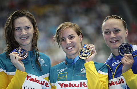CORRECTS NAME OF BRONZE MEDALIST - Australia's Bronte Campbell, centre, holds her gold medal with her sister and bronze medalist Cate, left, and silver medalist Sweden's Sarah Sjostrom after winning the women's 100m freestyle final at the Swimming World Championships in Kazan, Russia, Friday, Aug. 7, 2015. (AP Photo/Michael Sohn)