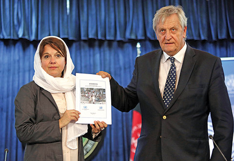 Danielle Bell, United Nations Assistance Mission in Afghanistan, UNAMA, Human Rights Director left, and Special Representative of the U.N. Secretary General for Afghanistan Nicholas Haysom, show a copy of the United Nations casualty report during a press conference in Kabul, Afghanistan, Wednesday, Aug. 5, 2015. The United Nations said on Wednesday that an increasing number of women and children were getting hurt or killed in Afghanistan's war against the Taliban and other insurgents. (AP Photo/Rahmat Gul)