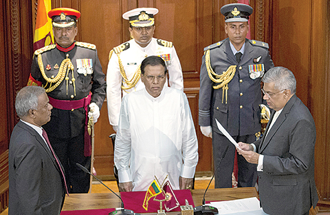 Ranil Wickremesinghe, right, takes oath as Sri Lankaís prime minister in front Sri Lankaís president Maithripala Sirisena, center, in Colombo, Sri Lanka, Friday, Aug. 21, 2015. Wickremesinghe's victory in Monday's election thwarted a political comeback bid by the country's former strongman president, Mahinda Rajapaksa, seven months after he lost his presidential re-election bid. (AP Photo/Gemunu Amarasinghe)