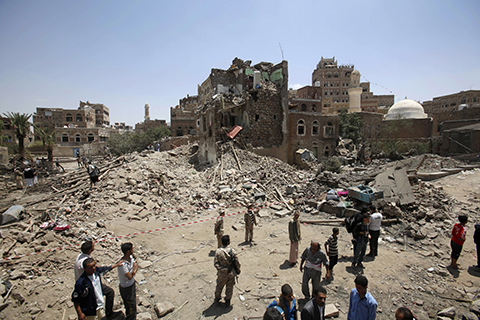 Civilians and security forces *gather near a house damaged in a Saudi-led airstrike in Sanaa, Yemen, Saturday, Sept. 19, 2015. The overnight airstrikes against Yemen's Shiite rebels and their allies have killed almost 30 people, including civilians, in the capital Sanaa, security and medical officials there said Saturday. The coalition's overnight airstrikes hit an apartment building in the center of the capital, a UNESCO world heritage site, killing a family of nine, the officials who remain neutral in the conflict that has divided Yemen's security forces said. (AP Photo/Hani Mohammed)