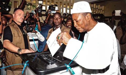 Guinea’s President and presidential candidate Alpha Conde casts his ballot at a polling station in Conakry. — AFP