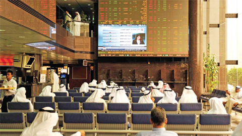 Traders check the price monitors at the Kuwait Stock Exchange. The KSE ended trading yesterday in the green zone, as the weighted index went up by 2.29 points, to stand at 391.52 points, and the price index also gained 20.55 points to reach 5,804.92 points. — KUNA