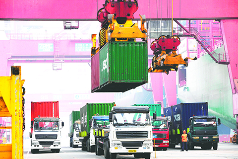 This photo taken on October 13, 2015 shows containers being transported in Qingdao port, eastern China's Shandong province. China probably grew at its slowest pace since the depths of the global financial crisis in the third quarter, an AFP survey has found, confirming investor fears following stock market turmoil and a currency devaluation. AFP PHOTO   CHINA OUT