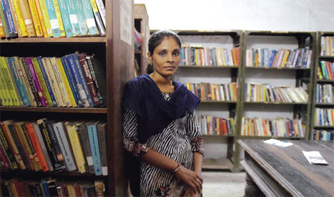 20 year old Indian student Santa Devi Meghwal, a victim of child marriage poses in her college library. — AFP