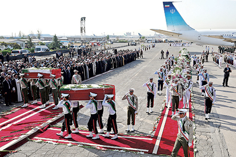 An Honor guard carries the coffins of Iranian hajj pilgrims who were killed in a deadly stampede in Mina near Mecca in Saudi Arabia on September 24, at Mehrabad airport in Tehran, Iran, Saturday, Oct. 3, 2015. The first plane carrying bodies of Iranian pilgrims killed in the hajj stampede in Saudi Arabia arrived in Tehran Saturday, nine days after the disaster that escalated tensions between the two regional rivals. President Hassan Rouhani and other senior officials were at the airport for the arrival of the plane, which carried 104 bodies. (AP Photo/Ebrahim Noroozi)