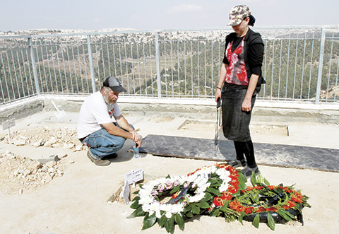 Israelis mourn next to the newly dug graves of Eitam and Naama Henkin, who were killed by suspected Palestinian gunmen the previous night as they were driving through the occupied West Bank, following their funeral in Jerusalem's cemetery on October 2, 2015. Israel deployed hundreds of troops in a hunt for suspected Palestinian gunmen after the couple were killed in front of their children in the West Bank. AFP PHOTO / GIL COHEN-MAGEN