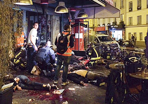 Victims of a shooting attack are seen on the pavement outside La Belle Equipe restaurant in Paris late Friday.