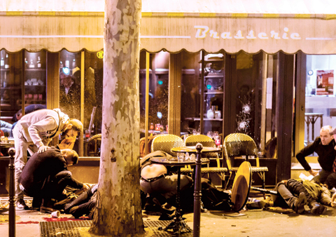 People lie on the pavement at the tarrasse of the Cafe Bonne Biere in Paris
