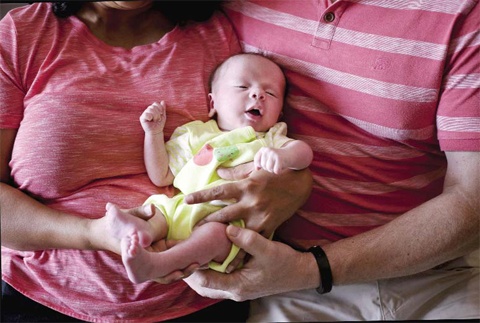 ANAND: A couple from Britain hold their baby, born on Oct 17 by a surrogate, in Anand, India. — AP