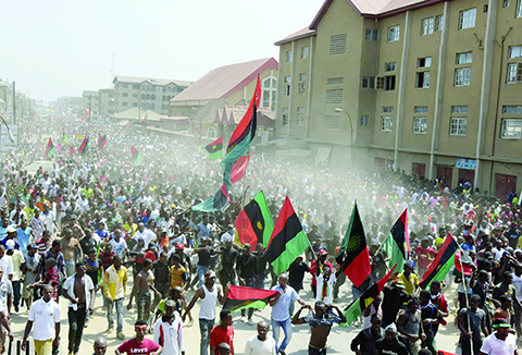 Hundreds of pro-Biafra supporters wave flags and chant songs as they march through the streets of Aba, southeastern Nigeria, to call for the release of a key activist on November 18, 2015. The protesters support the creation of a breakaway state of Biafra in the southeast and want the release of Nnamdi Kanu, who is believed to be a major sponsor of the Indigenous People of Biafra (IPOB) and director of the pirate radio station Radio Biafra. AFP PHOTO / PIUS UTOMI EKPEI