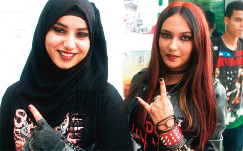 Algerian girls flash the ‘sign of the horns’, a gesture commonly used in rock and metal music culture, as they attend a rock and metal music festival ‘Fest 213’ in the northeastern Algerian city of Constantine.