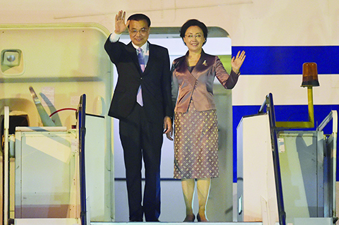 China's President Xi Jinping (L) and his wife Peng Liyuan (R) wave from their aircraft as they arrive to attend the 27th Association of Southeast Asian Nations (ASEAN) Summit, at the Bunga Raya Complex at the Kuala Lumpur International Airport in Sepang on November 20, 2015. Malaysia hosts the 27th ASEAN summit from November 18-22. AFP PHOTO / ADEK BERRY