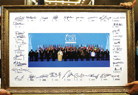ANTALYA, Turkey: A family photo, signed by the leaders, is displayed at the Group of 20 (G20) summit yesterday. — AFP