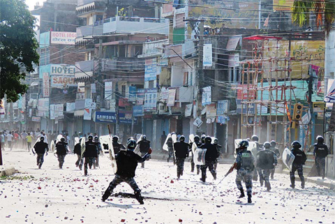 BIRGUNJ: Nepalese police walk protesters throwing rocks during clashes near the Nepal-India border at Birgunj, some 90 km south of Kathmandu. —AFP