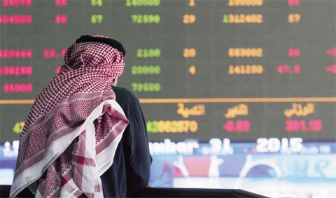 A Kuwaiti stock trader monitors the stock market activity at the Kuwait Stock Exchange (KSE) yesterday on the last trading day of 2015. Stock markets in the energy-rich Gulf states ended 2015 in negative territory impacted by a massive decline in oil prices and regional turmoil.