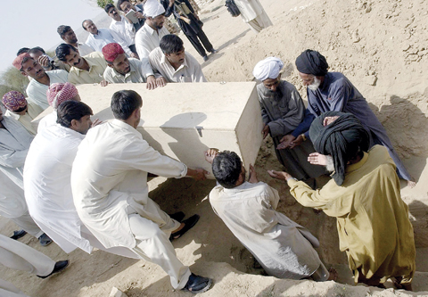 DERA BUGTI: In this file photograph taken on September 1, 2006, Pakistani tribal’s bury the coffin of rebel tribal chief Nawab Akbar Bugti, in the remote town of Dera Bugti in the southwest province of Baluchistan. — AFP