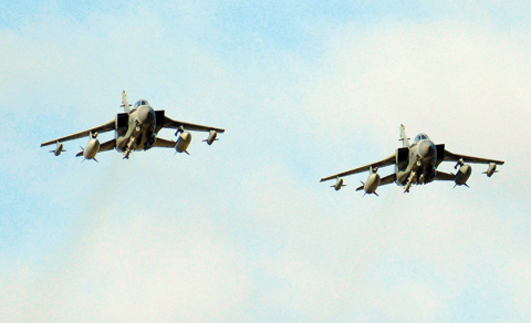 LIMASSOL: Two British Tornados warplanes fly over the RAF Akrotiri, a British air base near costal city of Limassol, Cyprus yesterday as they arrive from an airstrike against Islamic State group targets in Syria. (inset) A second pilot looks out from a British Tornado warplane. — AP