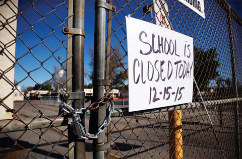 VAN NUYS: A gate to Birmingham Community Charter High School is locked with a sign stating that school is closed. — AP