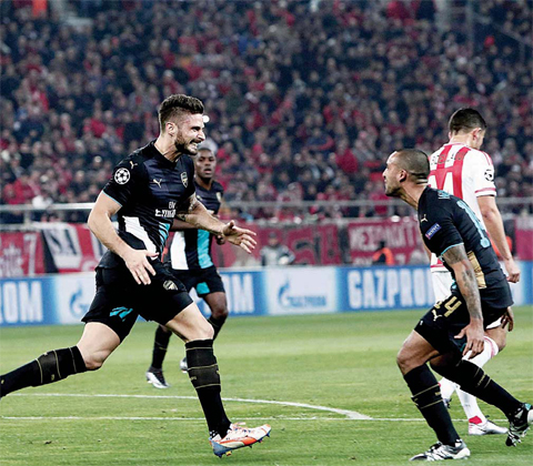Arsenal’s French forward Olivier Giroud (center) celebrates scoring 0-3 with teammates during the UEFA Champions League Group F football match between Olympiacos and Arsenal at the Georgios Karaiskakis Stadium in Piraeus. —AFP
