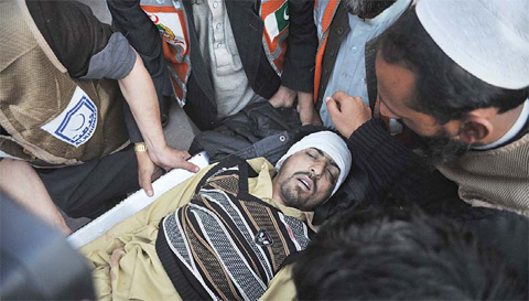 PESHAWAR: Pakistani paramedics transport a bomb blast victim to a hospital in Peshawar yesterday. - AFP