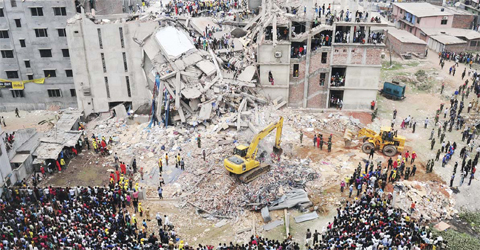 DHAKA: In this photograph taken on April 25, 2013, Bangladeshi volunteers and rescue workers are pictured at the scene after an eight-storey building collapsed in Savar, on the outskirts of the capital. — AFP