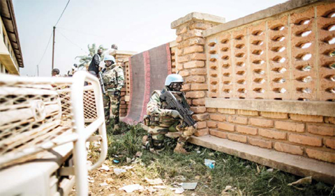 BANGUI: A Senegalese soldier from the MINUSCA, the United Nations mission in Central African Republic, takes position to respond to heavy gunfire directed towards the Baya Dombia school where voters gathered for the Constitutional Referendum.— AFP