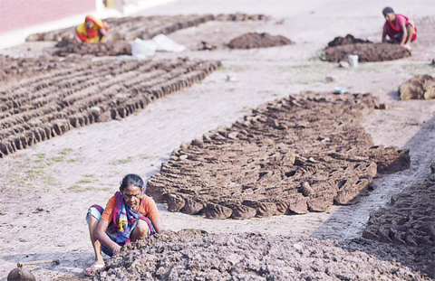 ALLAHABAD: Indian village women make cow dung cakes in Allahabad, India. In India, where Hindus have long worshipped cows as sacred, cow dung has been used for centuries as fuel for fires - whether for heat, cooking or in Hindu ritual fires, where it’s a necessity. —AP