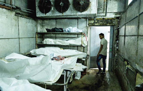 NEW DELHI: In this photograph an Indian medic walks through a cold storage unit as he inspects a morgue. — AFP photos