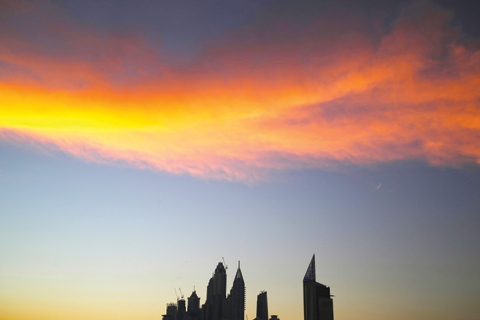 The setting sun sets wispy clouds aglow above the skyline of the Dubai Marina in Dubai yesterday. —AP