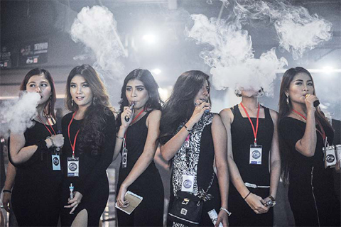 KUALA LUMPUR, Malaysia: Promoters smoke electronic cigarettes during the VapeFair in Kuala Lumpur. Vaping is an alternative to smoke by inhaling water vapor through a vaporizer utilized Propylene Glycol or Vegetable Glycerin based liquid, mixed with small amounts of nicotine and food grade flavoring that then get vaporized in a small battery powered atomizer. —AFP