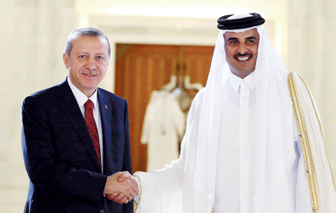 DOHA: Turkish President Recep Tayyip Erdogan (left) and Qatari Emir Tamim bin Hamad Al-Thani shake hands during a ceremony yesterday. - AP 