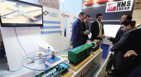 Iranian men look at a model of a train at the stand of the Russian company Yuzhno-Uralskiy Heavy Engineering yesterday during the Russia National Industrial Exhibition in Tehran. — AFP