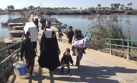 RAMADI: Displaced civilians from Ramadi and around the area cross the Bzebiz bridge as they leave their hometowns towards Baghdad on Monday. – AP 
