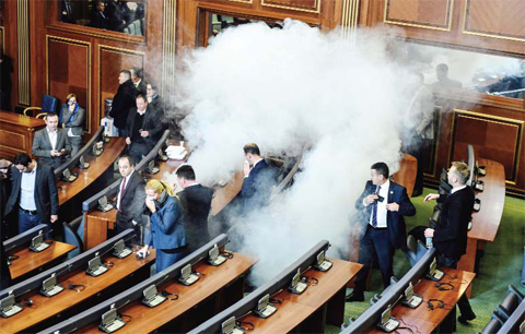 PRISTINA: Members of the Parliament disperse after a tear gas was launched by opposition lawmakers in the Kosovo’s parliament. — AFP