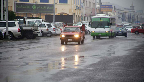 KUWAIT: Vehicles drive with their headlights turned on during heavy rains yesterday afternoon in Shuwaikh. —Photo by Yasser Al-Zayyat